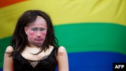 A doll with Vladimir Putin's face next to a gay rights flag as protesters demonstrate outside Downing Street in central London, in August, 2013.
