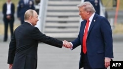 Președintele american Donald Trump îl întâmpină pe președintele rus Vladimir Putin înaintea întâlnirii lor de la Anchorage, în august.