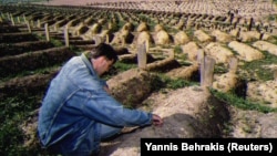 Într-un cimitir construit pe stadionul Kosevo din Sarajevo un bărbat își jelește mama, Vasvija, care a fost ucisă de un lunetist în septembrie 1993.