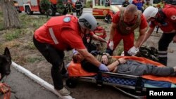 Personalul medical acordă îngrijiri unui rănit lângă un bloc de apartamente lovit de un atac cu drone rusești, la Harkov, Ucraina, 18 august 2025.