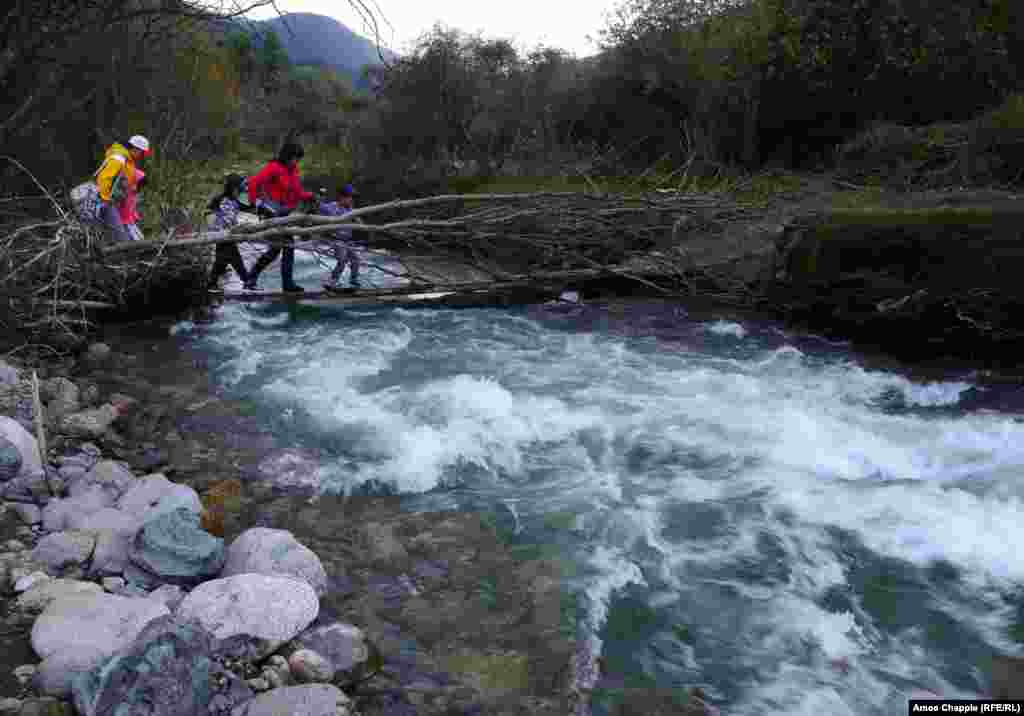 Көрүүчүлөр дарыядан өтүүдө.