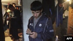 Young Tajik migrant workers send text messages from their shared residence in the Russian capital, Moscow. (file photo)