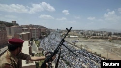 Йемендин борбору Санаа шаарында өкмөттүк күчтөрдүн жоокери оппозициячыл жыйынды байкап карап турат. 2011-жылдын 3-июну, түшкө чейинки маал.