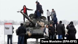 Armament rusesc greu se află deja în estul Ucrainei. E folosit de separatiștii sprijiniți de Moscova. În conflictul armat început în 2014 au murit deja peste 13.000 de oameni. În imagine: locuitori din Luhansk se fotografiază alături de un tanc T-72 al separatiștilor, în 2020.