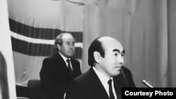 Жогорку Кеңеште Кыргызстандын туңгуч президенти болуп шайланган академик Аскар Акаевдин артында Кыргызстан КП БК Биринчи катчысы, Жогорку Кеңештин төрагасы Абсамат Масалиев турат.  27.10.1990. (КДКнын "Майдан" гезитинен).