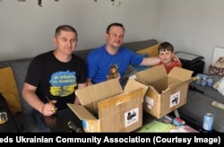 ვიაჩესლავ სემენიუკი (მარცხნივ) სხვა მოხალისესთან ერთად ერთჯერადი ვეიპების დასაშლელად მზადდება.