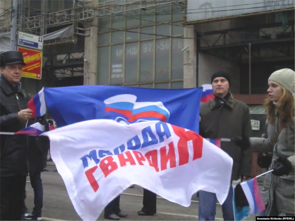 Маленькие российские флаги, флаг "Единой России" и движения "Молодая гвардия", - такова была атрибутика митинга