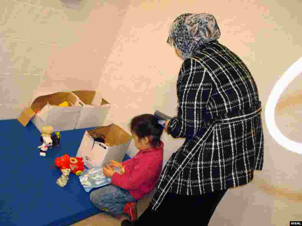 Қабылдауға дайындалып жүрген 14 жасар босқын Айнұр Нұрғалиева сіңлісінің шашын тарап,  өріп жатыр. - Беженка Айнур Нургалиева причесывает сестре волосы и готовится к входу в лагерь беженцев.