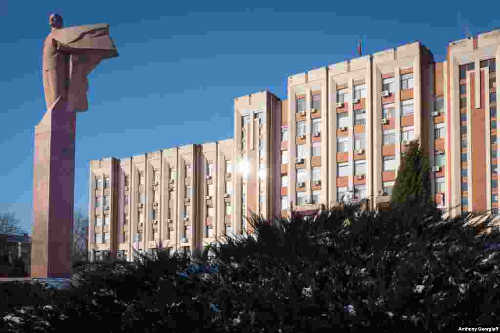 A statue of Vladimir Lenin stands in front of a government building.