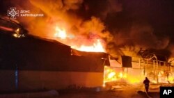 Fotografie oferită de Serviciul ucrainean de urgență. Pompierii sting incendiul la un depozit în urma unui atac rusesc în Ciuhuiv, regiunea Harkov. 17 martie 2025. 