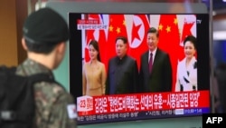 Військовослужбовець Південної Кореї на залізничній станції у Сеулі спостерігає з екрану повідомлення про візит лідера КНДР до Китаю, 28 березня 2018 року