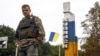 Український військовий біля знаку з написом «Куп’янськ» у відвойованому напередодні ЗСУ місті Куп’янську на Харківщині, 14 вересня 2022 року, ілюстративне фото