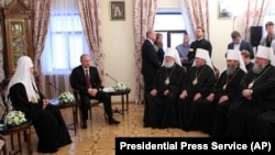 Довоєнна фотографія, Київ, Києво-Печерська лавра, 27 липня 2013 року. Московський патріарх Кирило (ліворуч), президент Росії Володимир Путін (другий зліва), а напроти учасники синоду УПЦ (Московського патріархату), серед яких митрополит Онуфрій (другий справа)