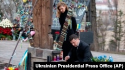 Ukrainian President Volodymyr Zelenskiy and his wife, Olena, pay their respects at the memorial dedicated to people who died in clashes with security forces in 2014 at Independence Square in Kyiv on February 20.