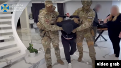 Captură de ecran dintr-un videoclip postat pe canalul de YouTube al Serviciului de Securitate al Ucrainei, care arată reținerea unui bărbat suspectat de spionaj.