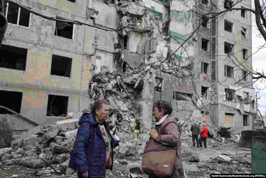 Localnici din Kosteantînivka, în fața unei clădiri distruse. Regiunea Donețk, mai 2025.