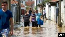 Луѓе поминааt низ надојдените води на 7 август 2016 година во селото Стајковци, близу Скопје, по поројните дождови и силните бури во текот на ноќта.