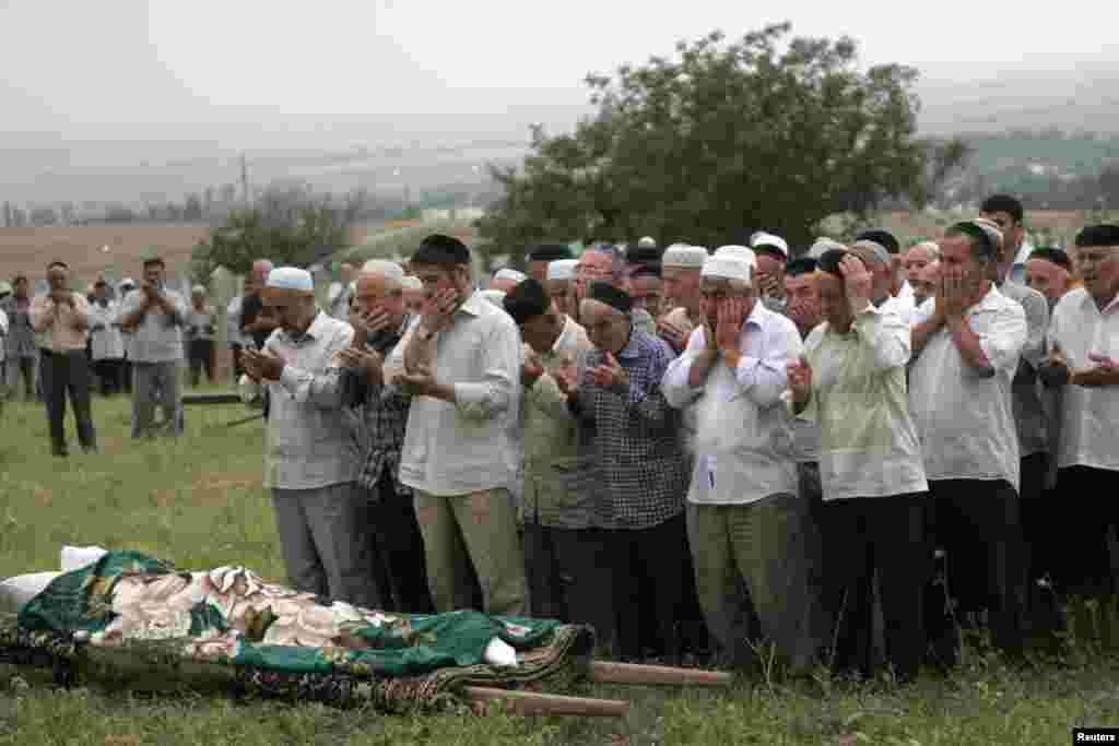 Mourners gather for the Estemirova's funeral in Koshkeldy, about 70 kilometers east of Grozny on July 16, 2009.