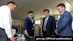 Председатель Государственной регистрационной службы Дастан Догоев (второй слева), премьер-министр Сооронбай Жээнбеков (третий слева) и директор Государственного агентства связи Бакыт Шаршембиев (справа). 15 августа 2017 года.