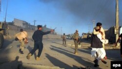 Afghan security officials shift injured victims from the scene of a suicide bomb attack that targeted a conoy of foreign forces in Lashkar Gah, Helmand in November.