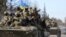 Военнослужащие Украины едут на бронетранспортерах в освобожденном от российских военных городе Тростянец Сумской области, 28 марта 2022 года
