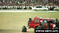 Një vrasës i dyshuar është gjunjëzuar në qendër të stadiumit kombëtar të futbollit në Kabul, pak para se të vritej nga vëllai i viktimës, 13 mars, 1998.