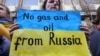Një grua gjatë një proteste në Bruksel mban një pano ku shkruan: "Jo gaz dhe naftë nga Rusia". Belgjikë, 11 mars 2022.