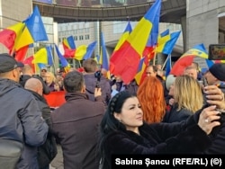 O femeie din staff-ul AUR se fotografiază cu protestatarii.