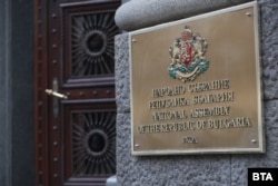 Табела с държавния герб, поставена до вход на бившия Партиен дом