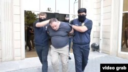 Sputnik Азербайжан агенттигинин башкы редактору Евгений Белоусов кармоо учурунда. Баку, 30-июнь 2025-жыл