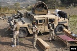 FILE: Members of Afghan security forces take positions during an operation against IS militants.