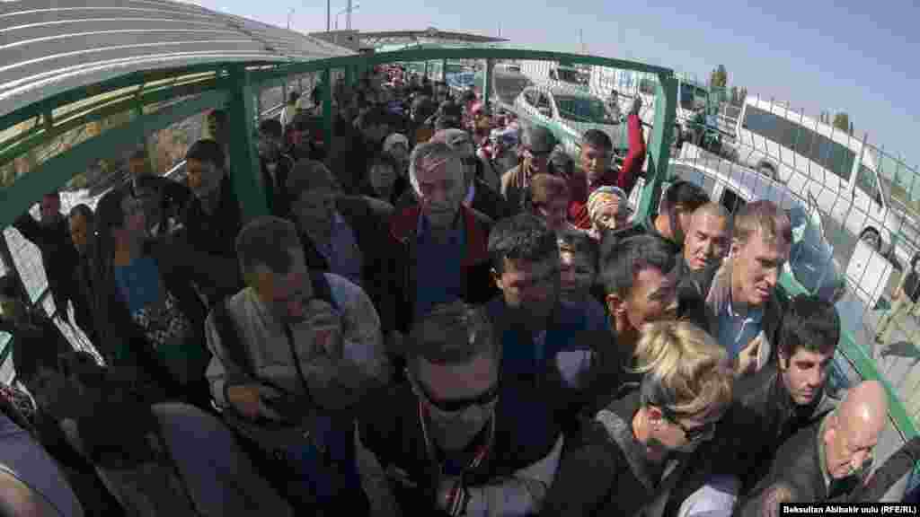 Люди в так называемом зеленом коридоре - огороженном металлической решеткой проходе - на подходе к казахстанскому КПП "Кордай". 12 октября 2017 года.