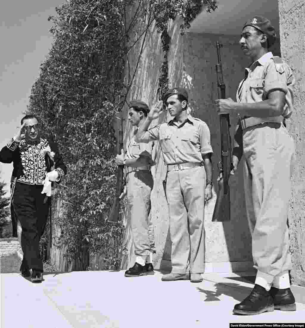 Эрон дипломати Ризо Саффиния 1950 йилда Тель-Авив яқинида жойлашган Исроилнинг илк президенти Хаим Вайцманнинг қароргоҳига кирар экан, исроиллик аскарларга салом бераяпти.1950 йилда Эрон янги ташкил топган яҳудий давлатини норасмий тан олиб, араб қўшниларидан фарқли йўл тутган эди.