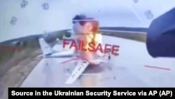 A Russian military aircraft is seen burning on video footage from a Ukrainian drone attacking the Belaya air base, near Russia's border with Mongolia.