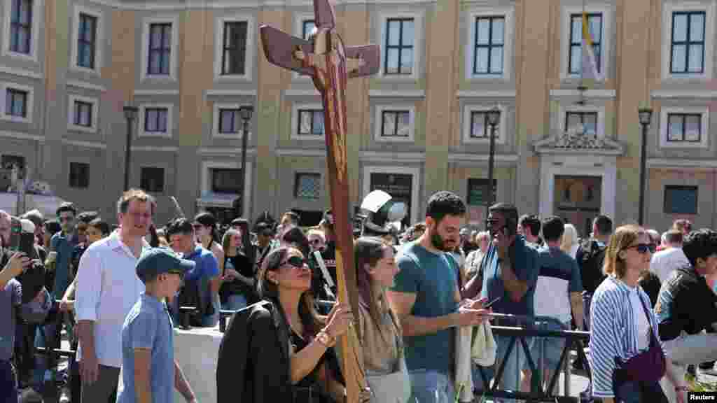 Žena drži krst na Trgu Svetog Petra u Vatikanu, nakon smrti pape Franje, u Rimu, Italija.