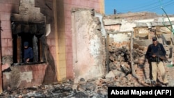 Police inspect the burned Hindu temple a day after a mob attack in a remote village in the Karak district, some 160 kilometers southeast of Peshawar, on December 31.