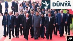 Hytaý lideri Si Szinpin (ortada) we daşary ýurt liderleri, şol sanda rus prezidenti Wladimir Putin (orta çep) we demrigazyk koreya lideri Kim Jong Un (orta sag) II Jahan urşunyň tamamlanmagynyň 80 ýyllyk dabarasynyň öň ýany, Tianmen Skweriniň münberine tarap ýöräp barýarlar.