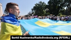 Акція під Верховною Радою України. Люди написали побажання на великому кримськотатарському прапорі, який запустили до Дня кримськотатарського прапора. Київ, 15 червня, 2021 року