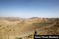 A soldier stands guard along the border fence outside the Kitton outpost on the border with Afghanistan in North Waziristan. (file photo)