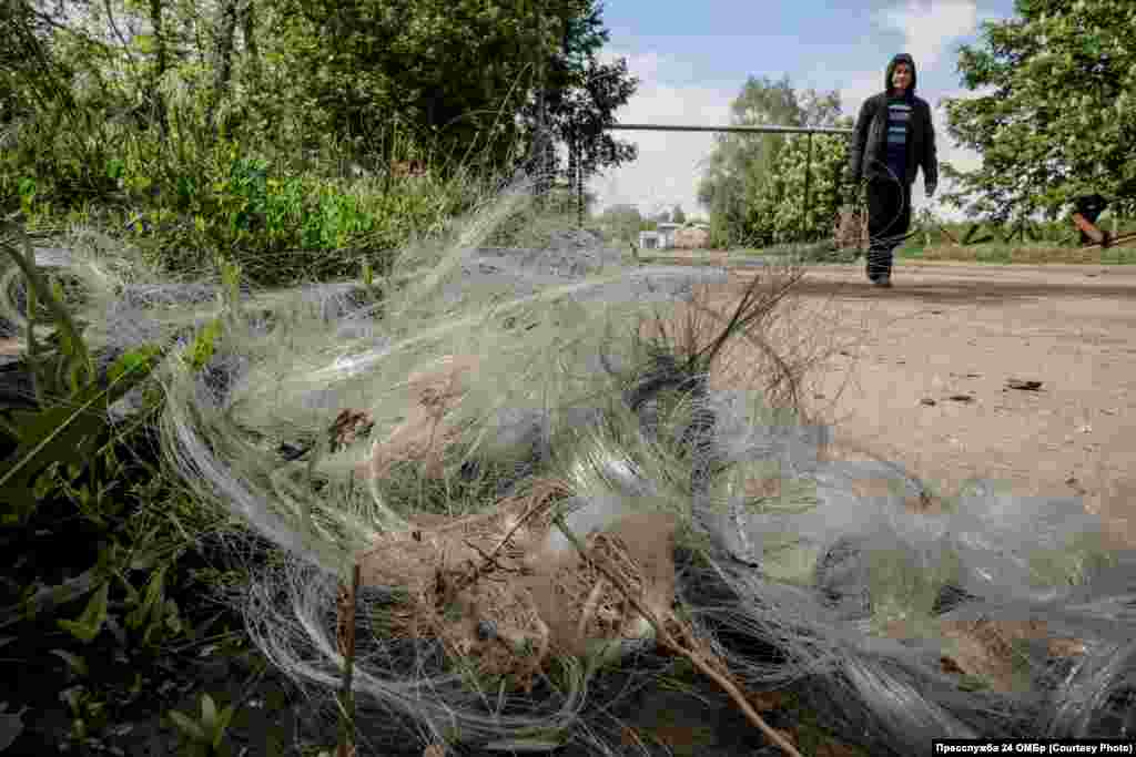 Dronele FPV reprezintă una dintre principalele amenințări. În fotografie: un bărbat trece pe lângă un cablu de fibră optică lăsat în urmă de un atac recent.