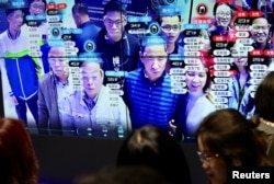 Visitors are seen at a screen displaying facial recognition technology at the Digital China Exhibition in Fuzhou, Fujian province, China. (file photo)