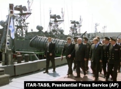Președintele rus Vladimir Putin (al treilea din dreapta față) trece pe lângă navele militare din Flota Caspică în Portul Astrahan, la aproximativ 1.280 km sud-est de Moscova, aprilie 2002.