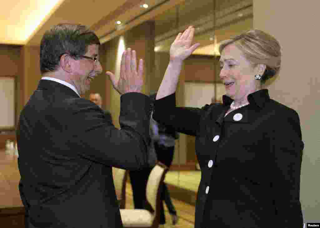 Hillary Clinton gives Turkish Foreign Minister Ahmet Davutoglu (left) a "high five" at the start of their bilateral meeting at the Emirates Palace Hotel in Abu Dhabi in the United Arab Emirates on June 9, 2011.