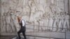 Muškarac prolazi pored bareljefa koji prikazuje fašističkog vođu Benita Mussolinija u naselju EUR poznatom po fašističkoj arhitekturi, u Rimu, Italija, 19. oktobar 2022. (Ilustrativna fotografija)