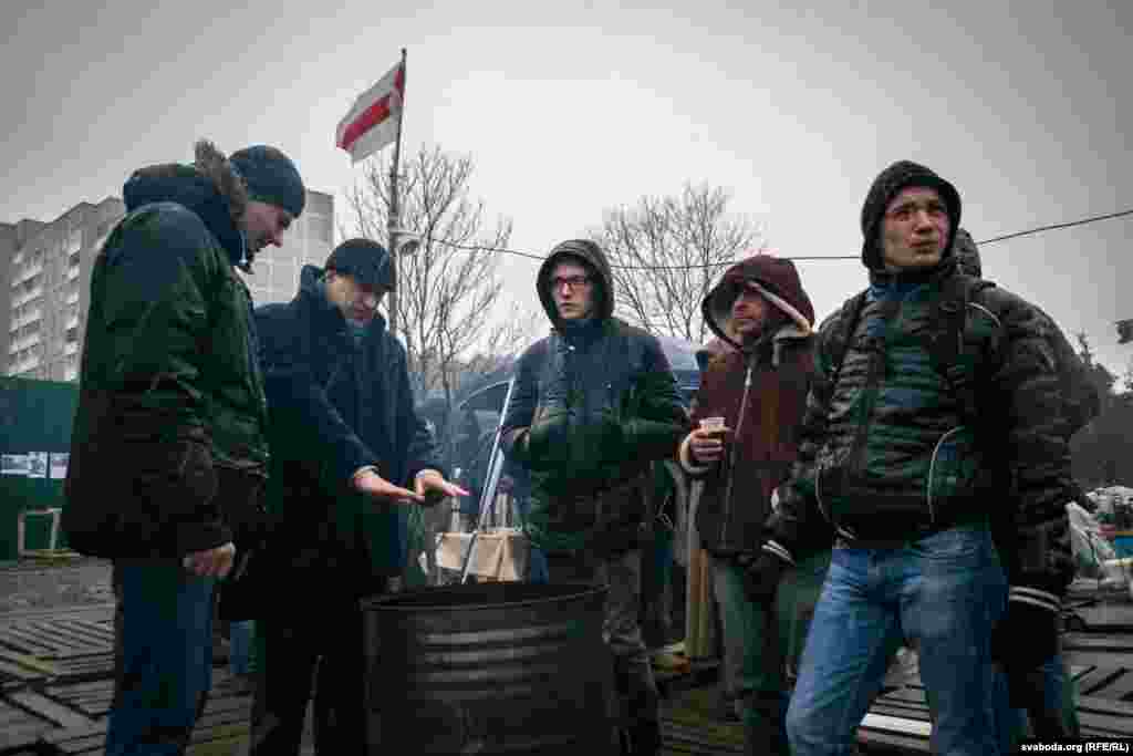 Трынаццаты дзень. Абаронцы спрабуюць сагрэцца ля бочкі, нягледзячы на дрэннае надвор'е.