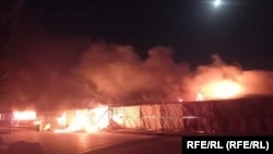 Un incendiu mistuie magazinele din districtul Andkhoi, provincia Faryab, după luptele recente dintre trupele afgane și talibani, 26 iunie 2021.