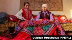 Бүбүзуура Ажымүдинова небереси менен. 
