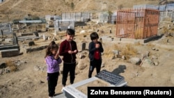 ادا احمدی ۷ ساله، همراه با پسران کاکایش در کنار قبر فرزاد ۱۲ ساله خویشاوند شان که قربانی حمله هواپیمای بدون سرنشین ایالات متحده شد ایستاده اند و برای وی دعا می‌کنند. این حمله که در ۲۹ آگست صورت گرفت منجر به کشته شدن ۱۰ غیرنظامی، از جمله هفت کودک در شهر کابل شد. ۷ نوامبر ۲۰۲۱