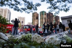 Кветкі ля згарэлых будынкаў. Ганконг, 28 лістапада 2025