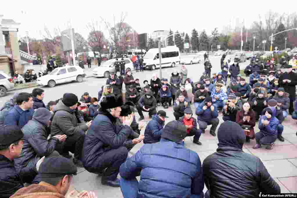 1986 жылғы Желтоқсан оқиғасына қатысушылардың құрметіне тұрғызылған "Тәуелсіздік таңы" ескерткіші жанында тәуелсіздік жолында күресте құрбан болғандарға құран бағыштап отырған адамдар. Алматы, 16 желтоқсан 2018 жыл.